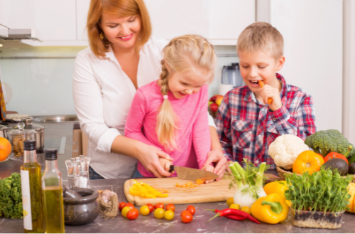 A mother teaching her children the art of cooking.