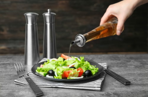 Vinegar is a natural flavor enhancer in food that adds tanginess and acidity. Commonly used in dressings and marinades, it also acts as a preservative, making it a versatile additive.